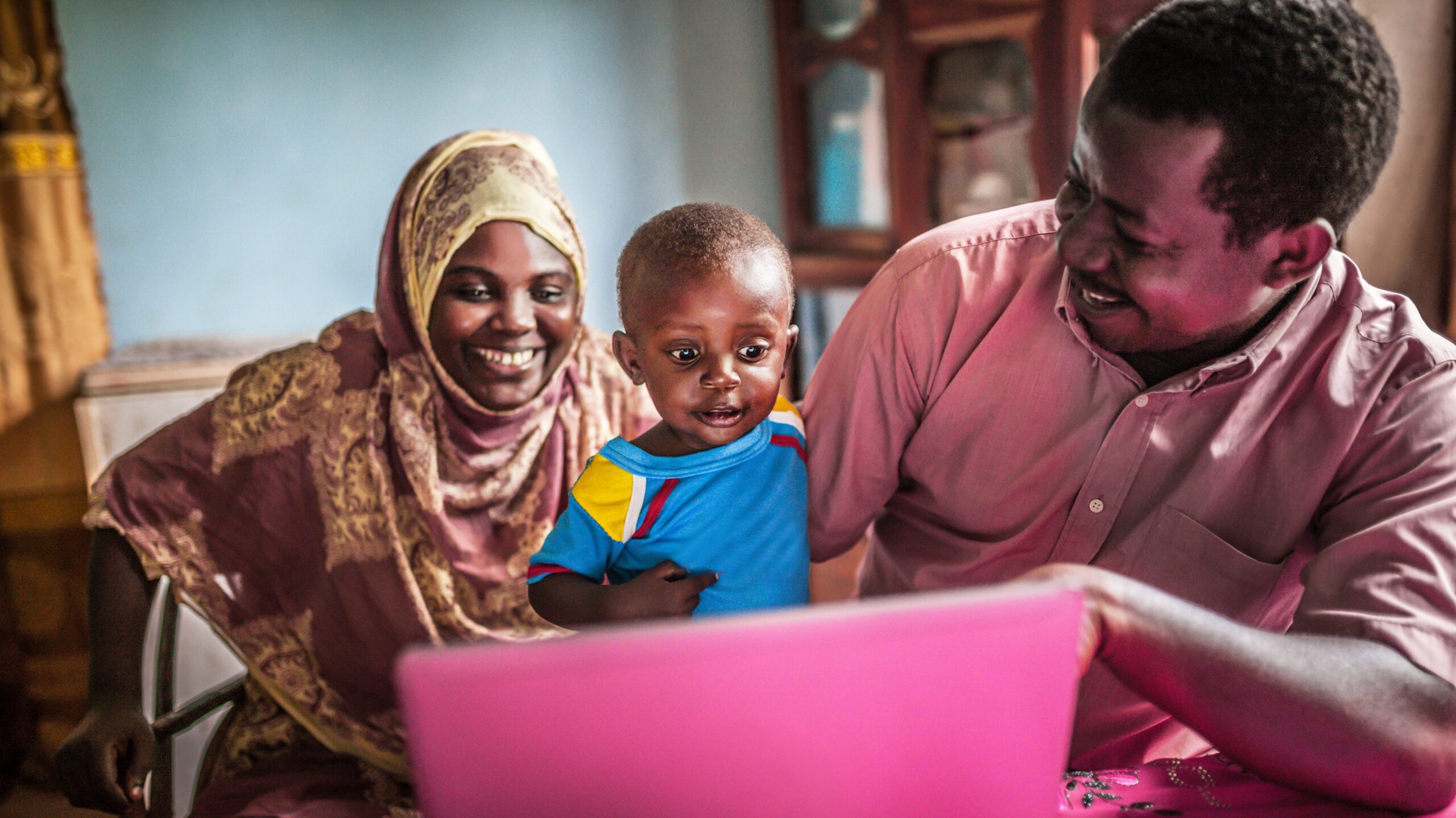 Happy African family sitting and using a laptop